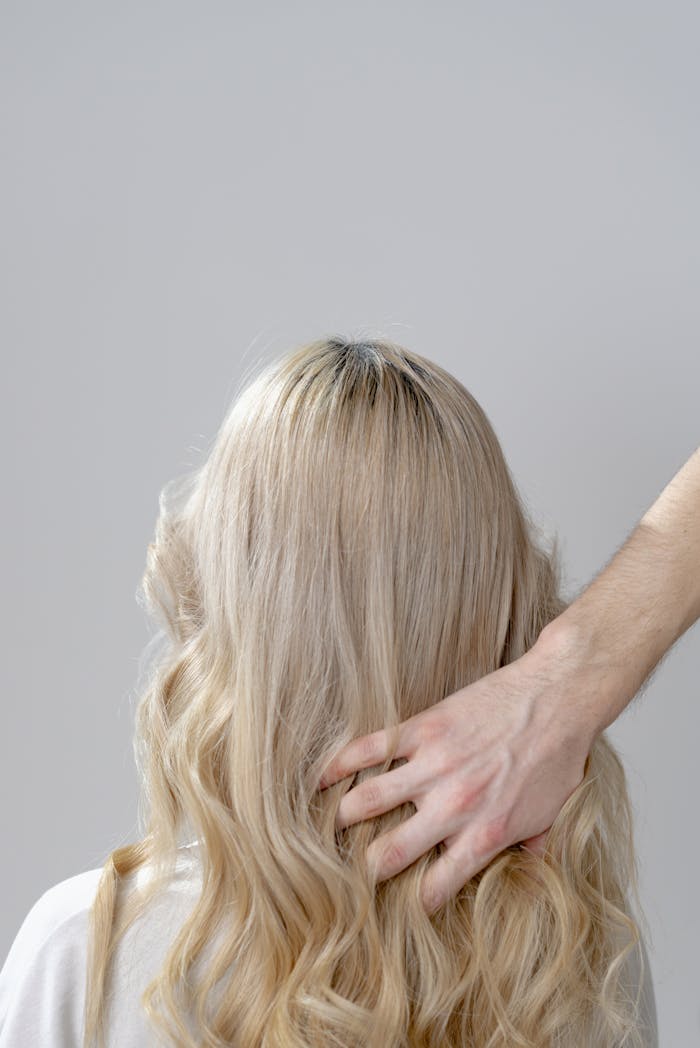 A woman with blonde curls styled gently in a hair salon setting.