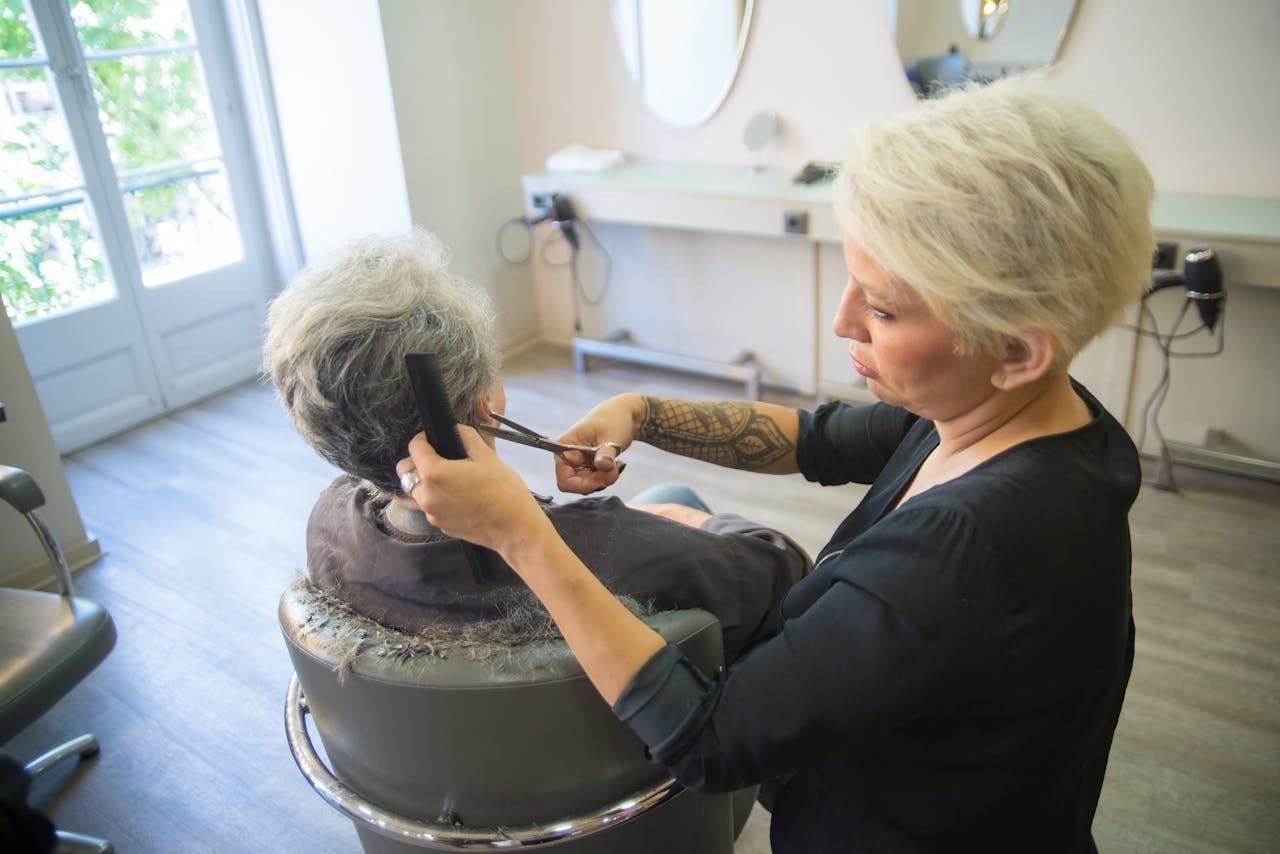 A hairdresser expertly cuts a client's hair in a modern salon setting, showcasing skill and style.